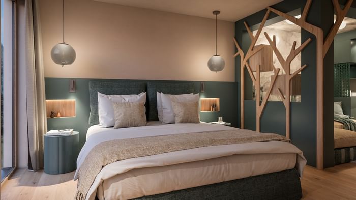 Camera da letto con letto matrimoniale, decorazioni in legno e pareti verdi e beige.