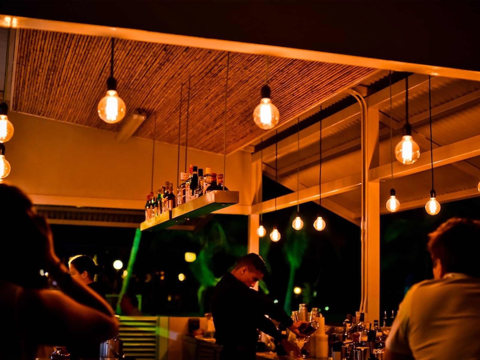 People under vintage lights at EI Pelicano Bar in Fiesta Resort