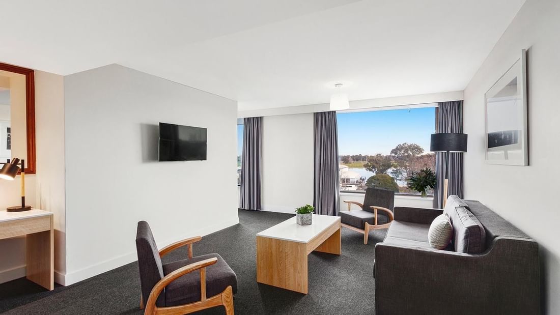Living area with seating and carpeted floors in Mercure Superior One-Bedroom Lakeview Suite at Pullman Albert Park