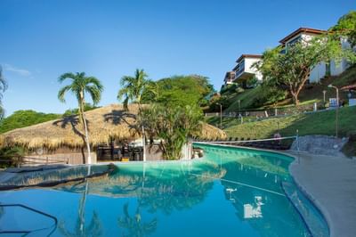 An outdoor pool with palm trees at Villas Sol Beach Resort