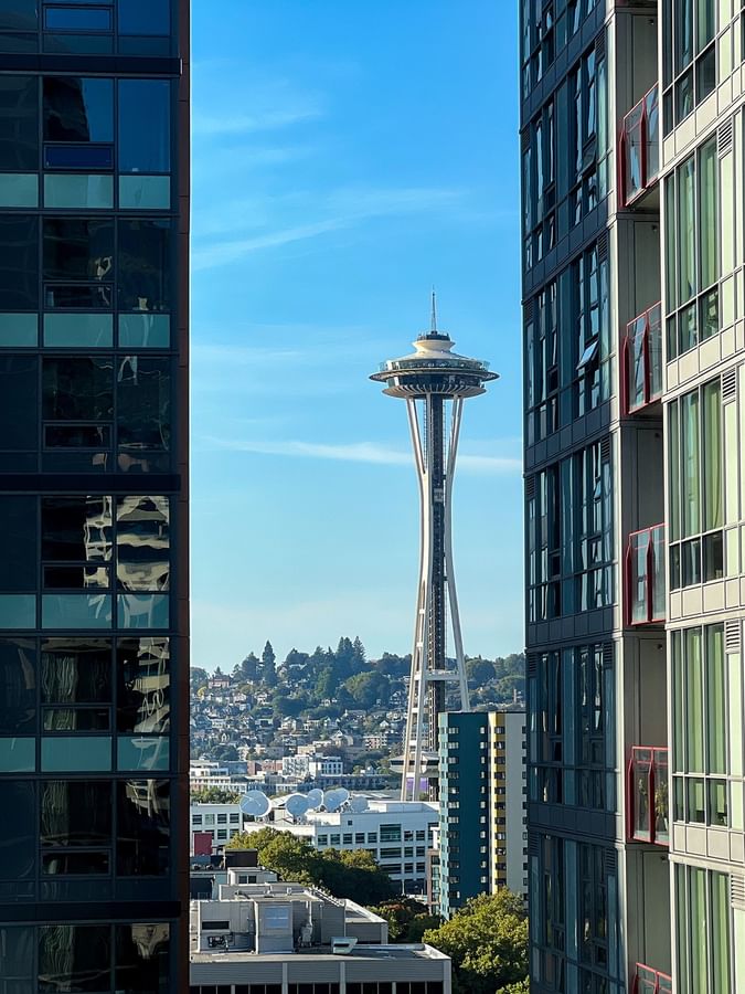 View of the Space Needle by high-rise city buildings under a blue sky in Premier Room  at Warwick Seattle