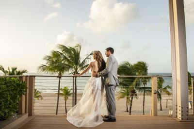 Bride & Groom posing by the railing at Isla Verde Weddings