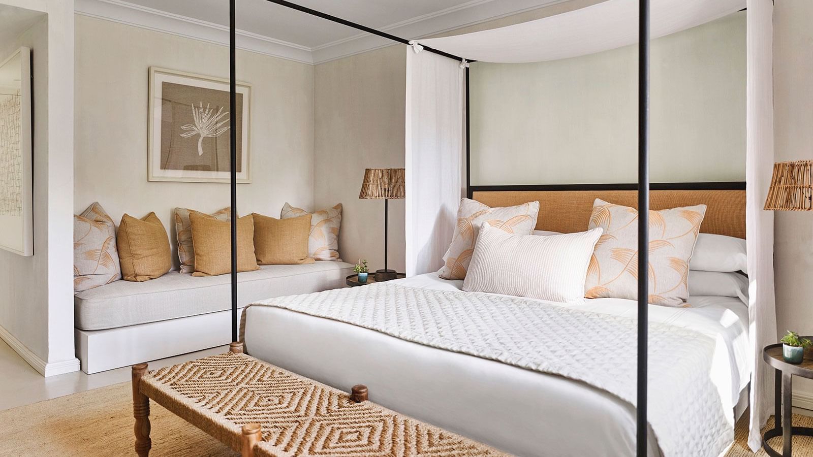 Four-Bedroom Villa with bed, woven bench, and daybed with neutral and amber pillows at Marbella Club