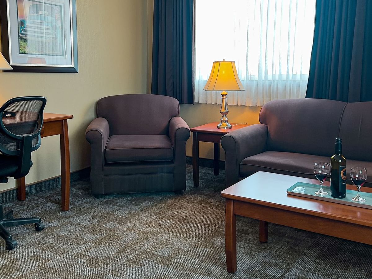 Living area of hotel suite with sofa, chair, table, coffee table
