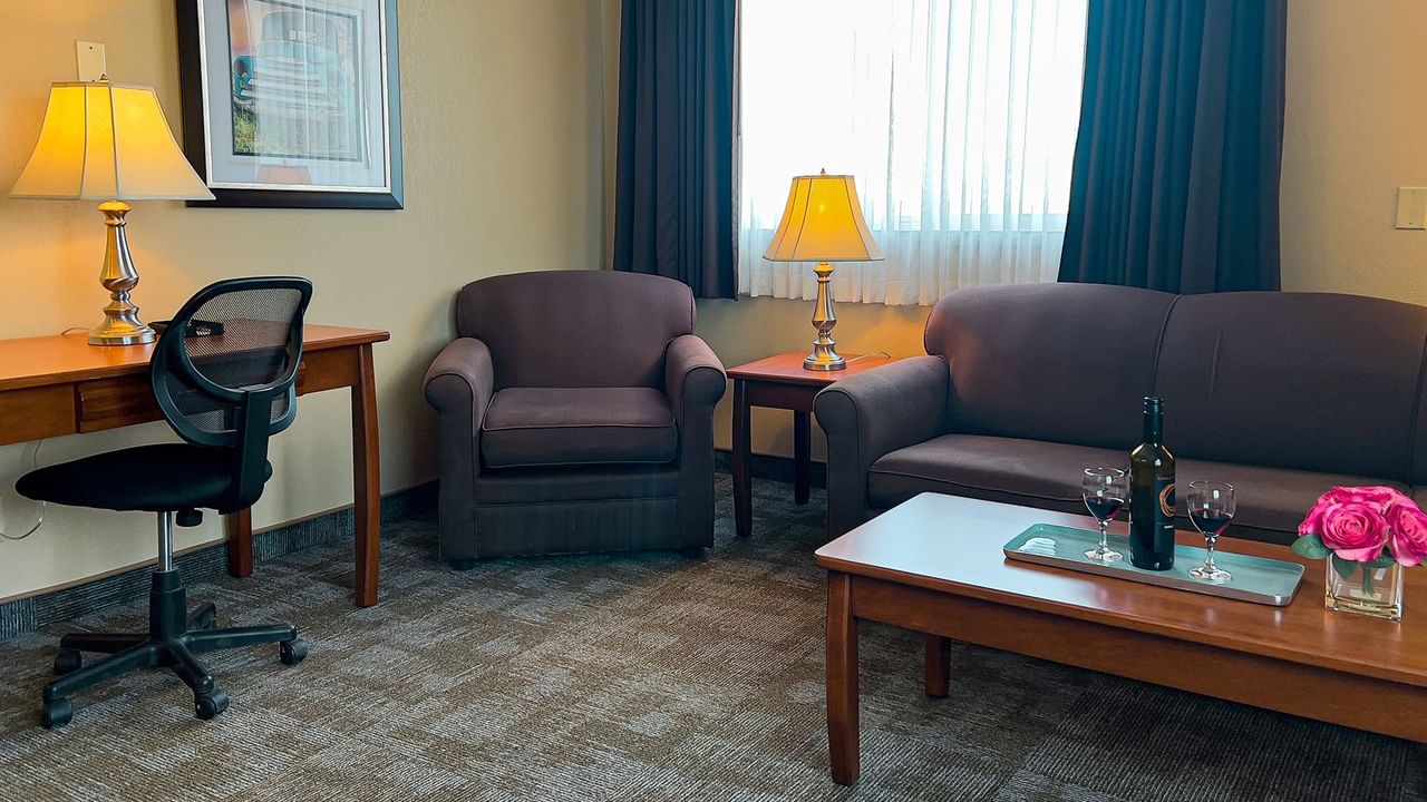 Living area of hotel suite with sofa, chair, table, coffee table