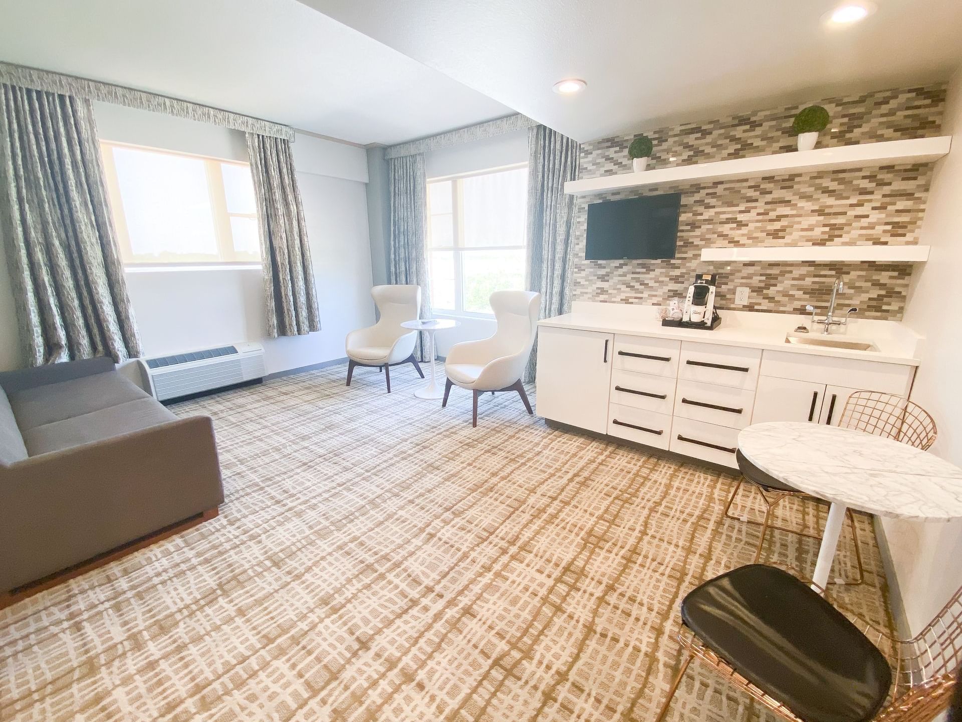 A kitchenette area with a cozy couch and chairs in the Executive Suite at The Fredonia Hotel