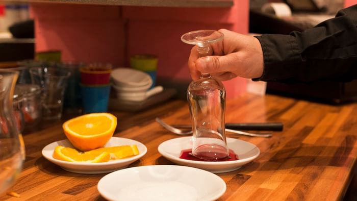 A waiter pours cherry syrup into the glass at Hotel le cheval.