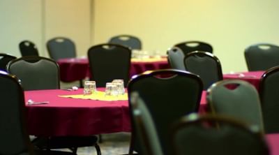 Modern banquet hall at Moab Valley Inn with round tables in maroon cloth, neatly set with glasses and silverware