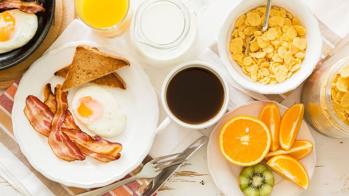 Breakfast with eggs and bacon by a coffee cup and cereal bowl on a white table at Warwick Ankara