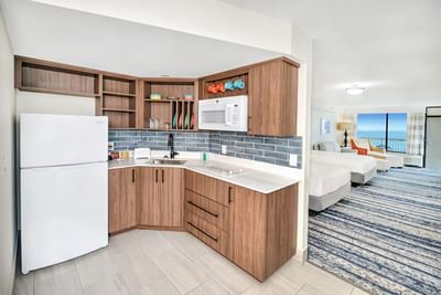 Deluxe Ocean Front Kitchenette with white refrigerator, wooden cabinets, and white countertop