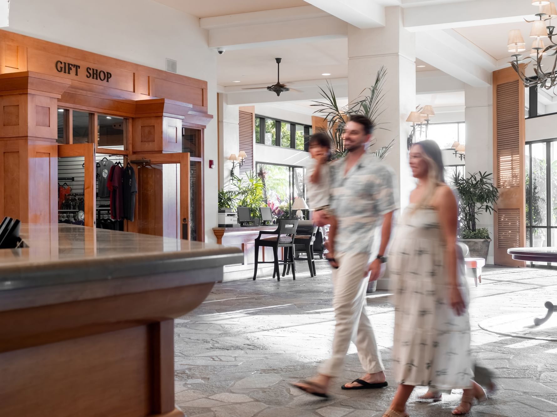 Blurred photo of a family walking by the front desk at the Maui Coast Hotel