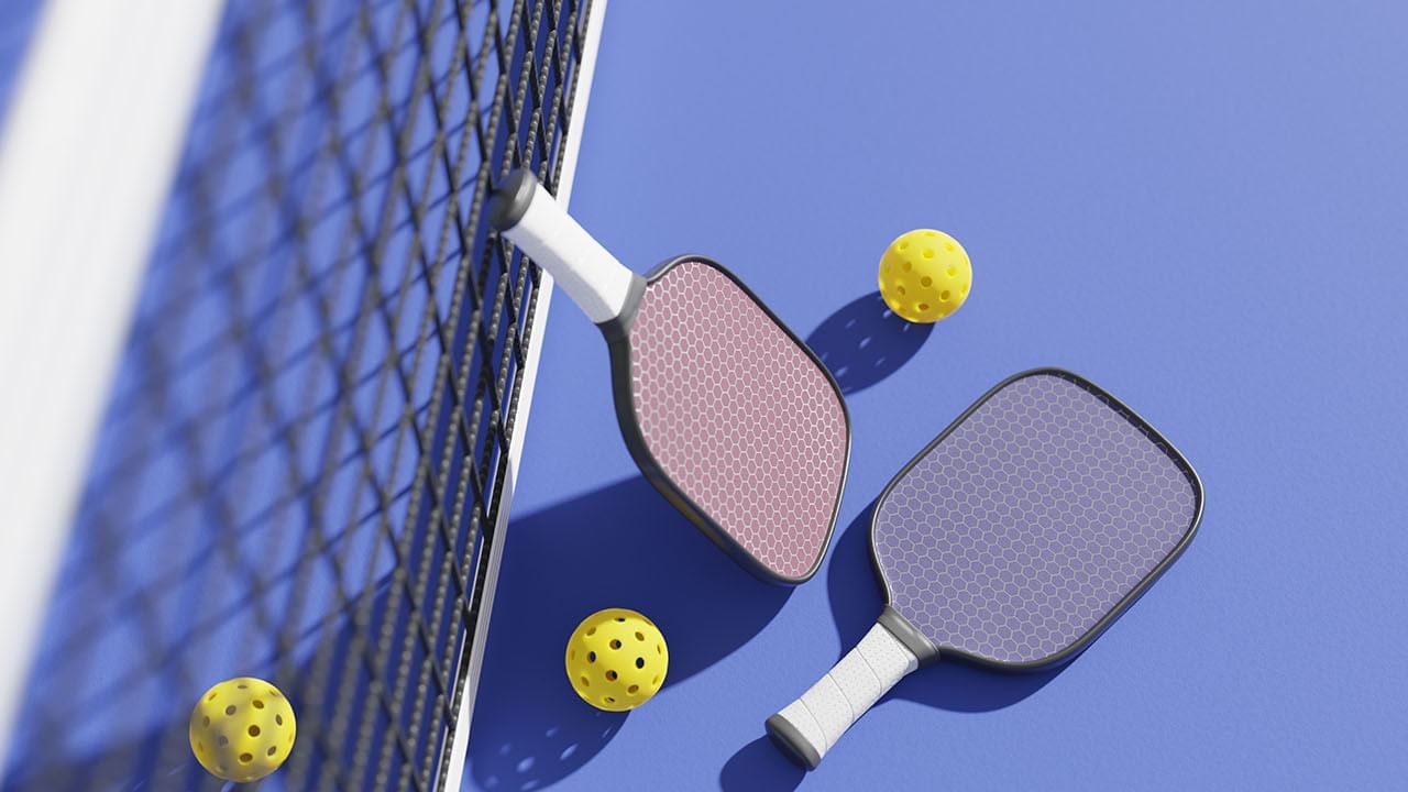 Close-up of rackets and balls by a net in the Pickleball court at Cove Pocono Resorts