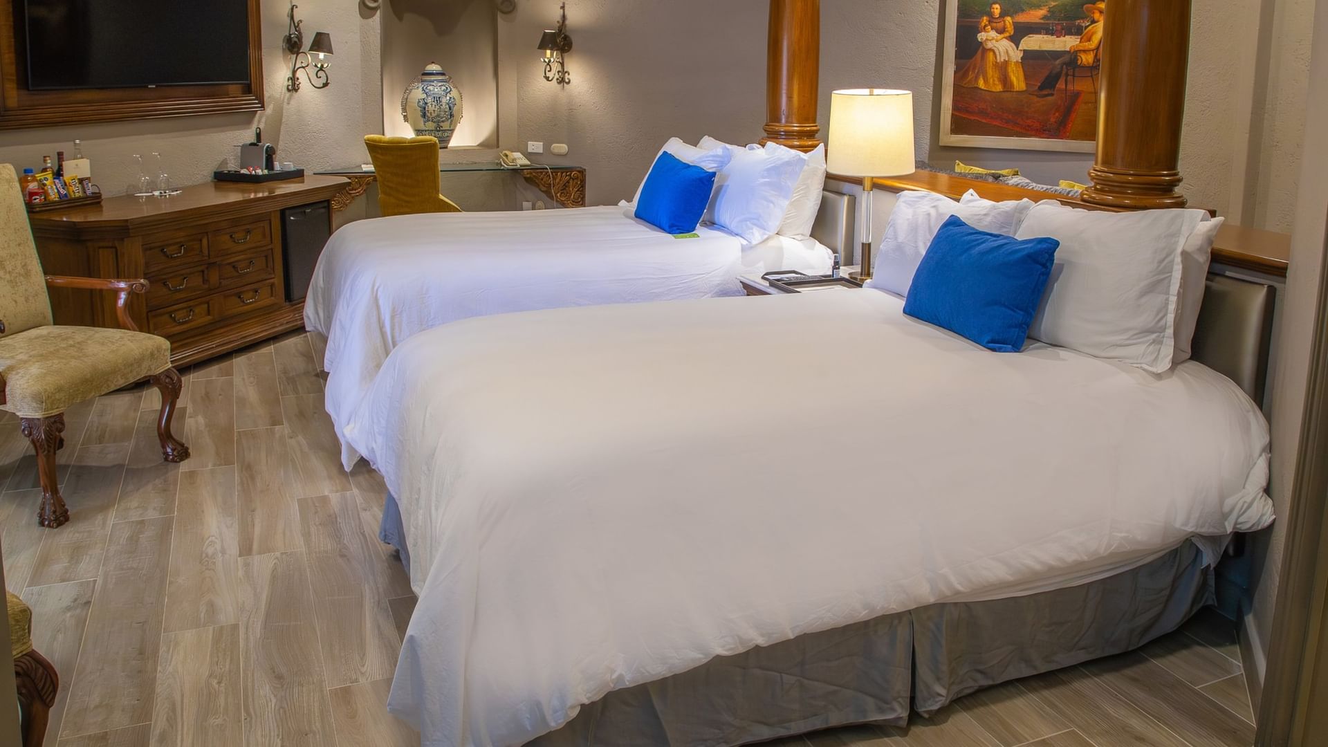 Spacious 2 Double Grand Class room with white bedding, blue accent pillows, and elegant colonial decor at Quinta Real Guadalajara