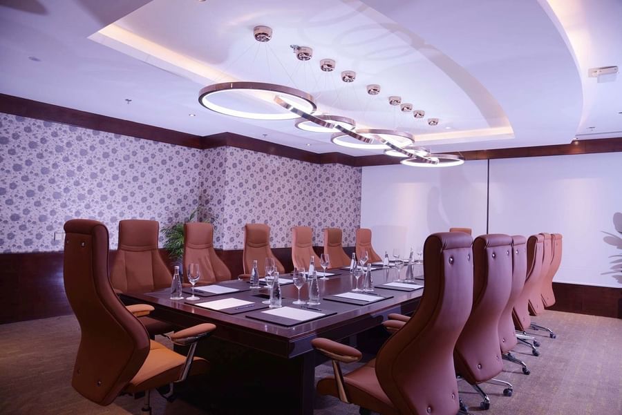 High-back tan leather chairs surrounding a dark wood conference table in Pearl 1 at Warwick Al Khobar
