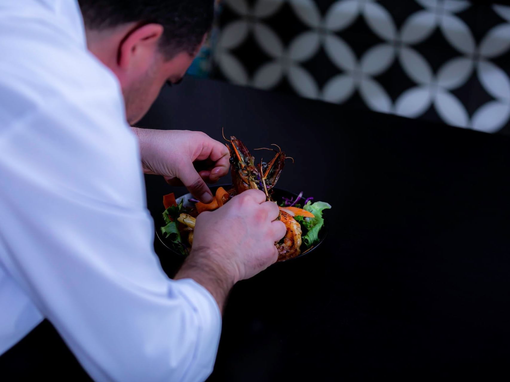 A Chef garnishing a fine dish served at Cardoso Hotel