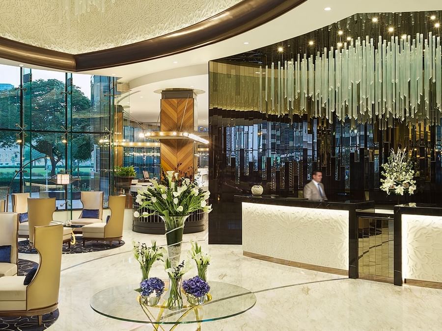 Luxurious lobby with reception area, elegant seating, and striking glass chandeliers at DAMAC Hotels & Resorts