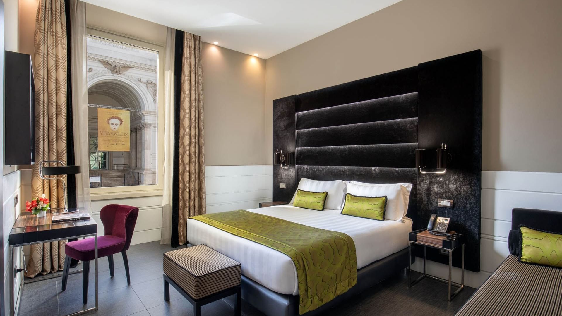 Work desk with bed by the window and wooden flooring in Deluxe Room at The Glam Hotel