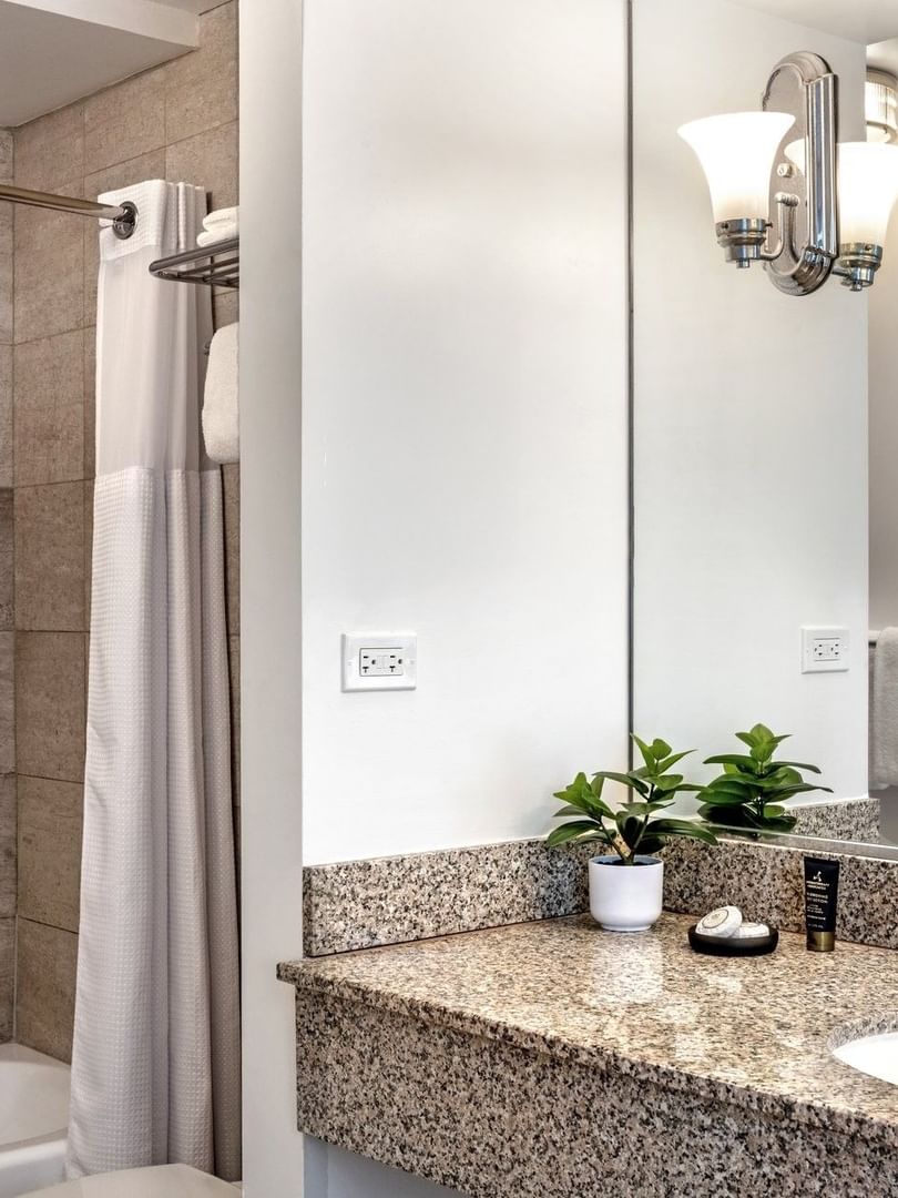 Standard Room bathroom featuring marble vanity by the bathtub at Warwick Allerton Chicago