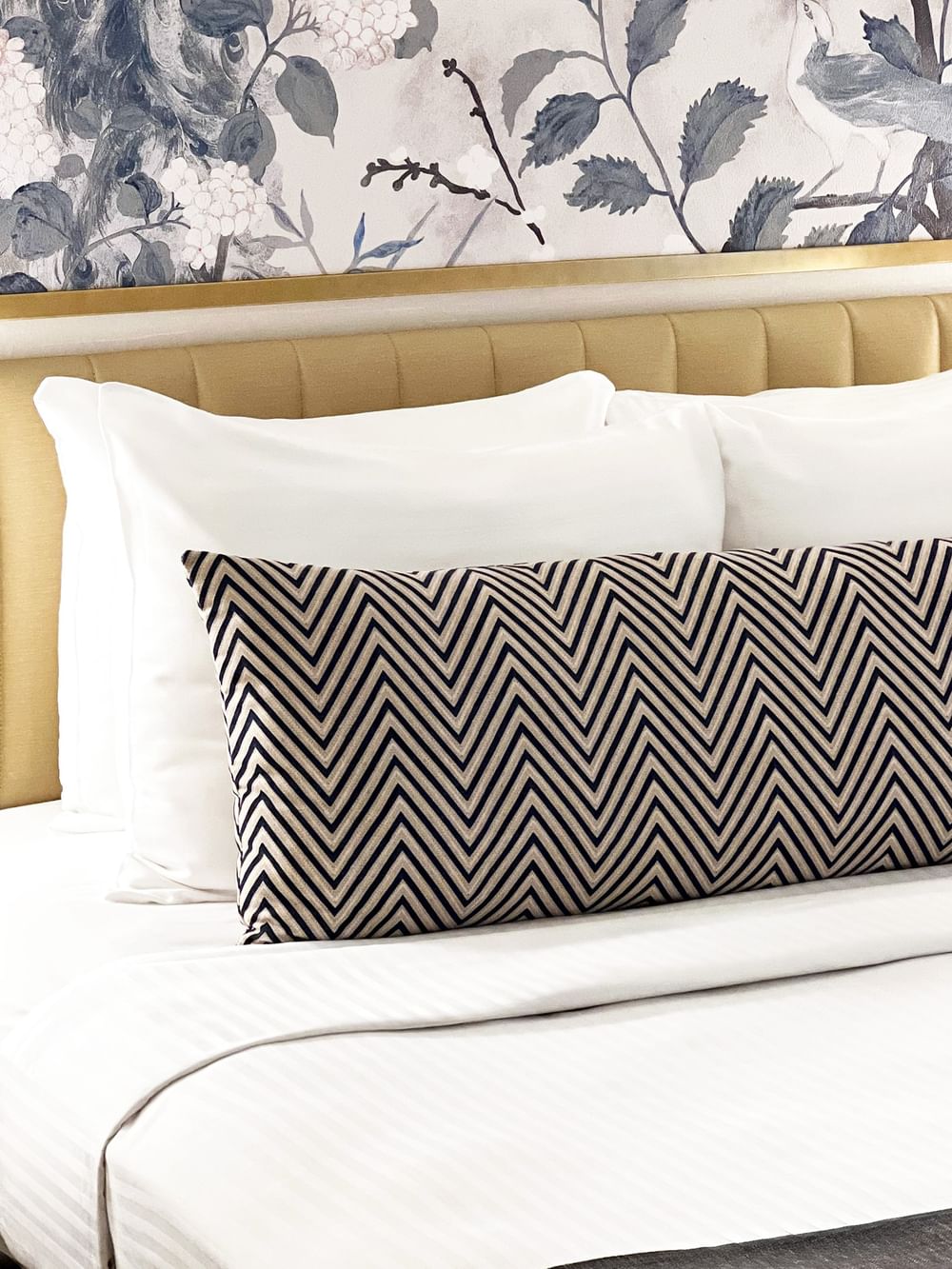 Close-up of a bed with a patterned pillow in Petite Classic at Warwick Allerton Chicago