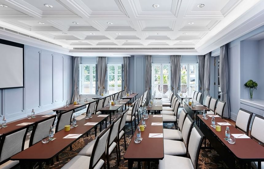 Classroom-type table arrangement with a screen and windows overlooking the outdoors at Park Hyatt Saigon