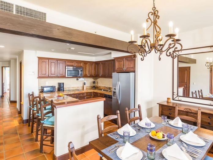 Dining area with chandelier and full kitchenette with cabinets in the Three Bedroom Villa at Hacienda Del Mar Los Cabos.