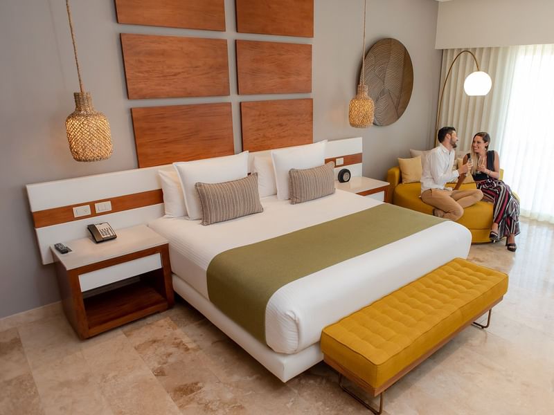 Pareja conversando en un sofá de la habitación doble del Reef Resort 28 en Playa del Carmen