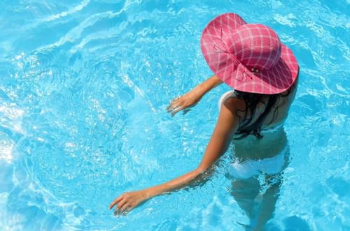 Girl in pool with beach hat