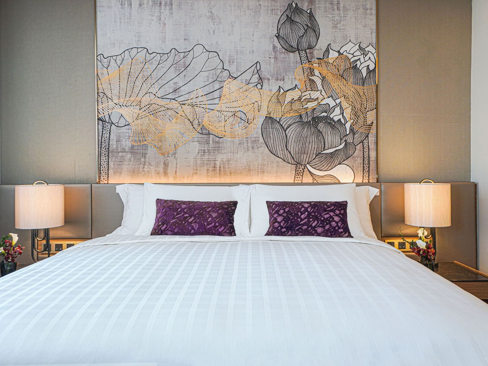 An inviting bed adorned with pristine white sheets and plush purple pillows, offering comfort and relaxation