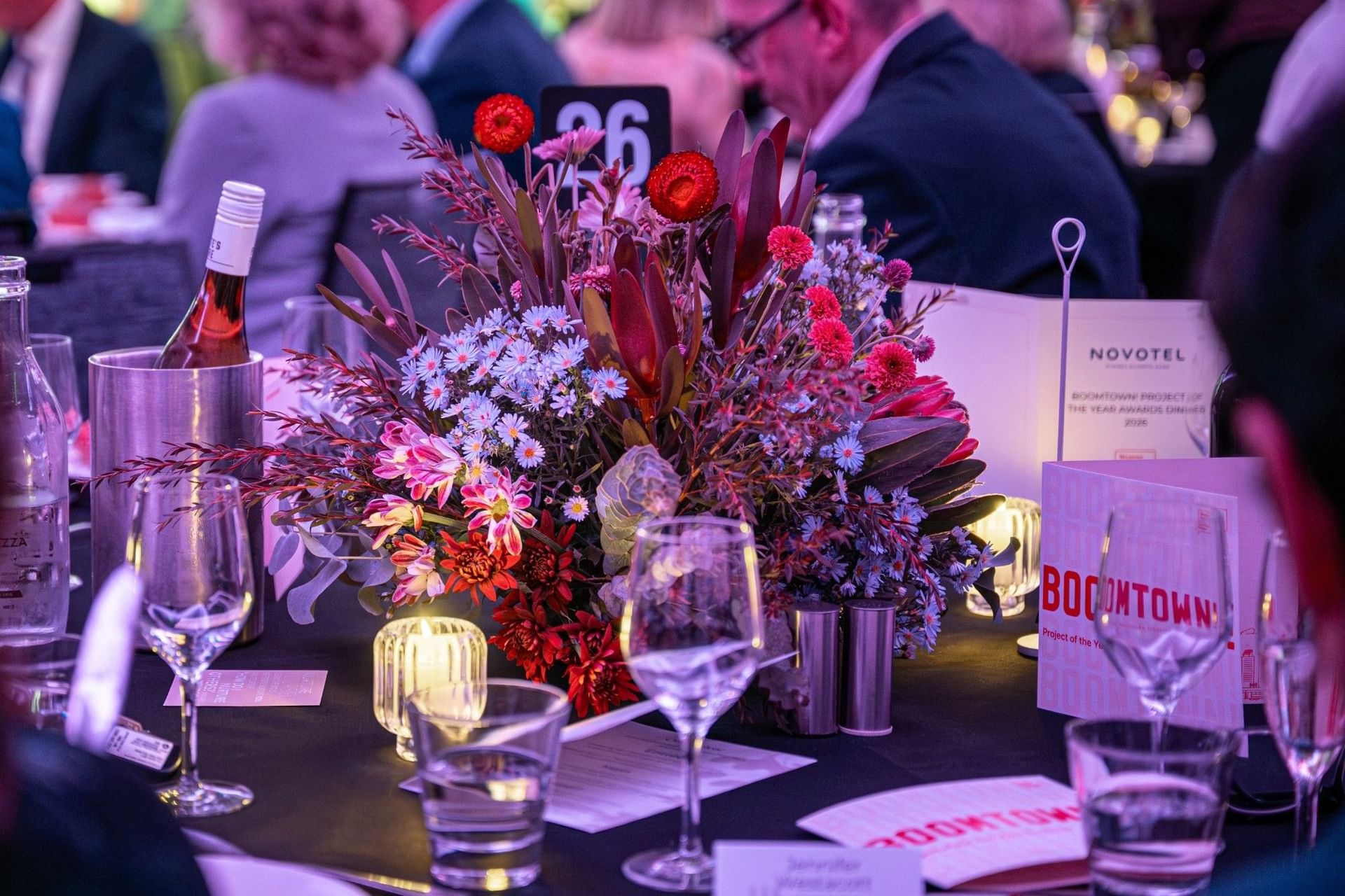 Table centerpiece with red and purple flowers in the Freshwater Room at Novotel Sydney Olympic Park