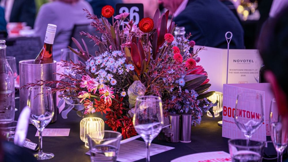 Table centerpiece with red and purple flowers in the Freshwater Room at Novotel Sydney Olympic Park