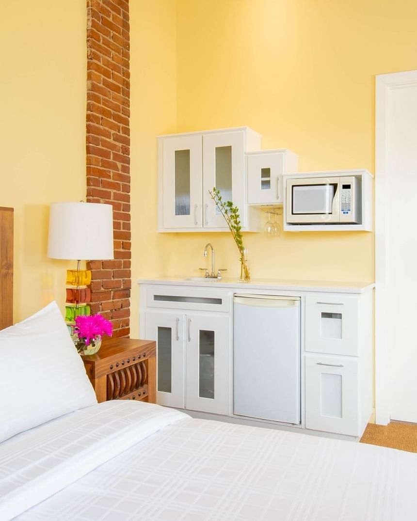 queen bed facing kitchenette with microwave and mini fridge