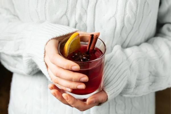 Women holding glass of mulled wine, as we explore the question of how sweet it is