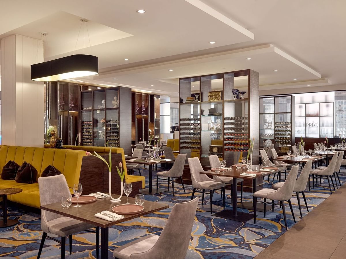 Dining area with yellow and grey chairs, and set tables in Restaurant Bistro Suzette at Sofitel Brisbane Central