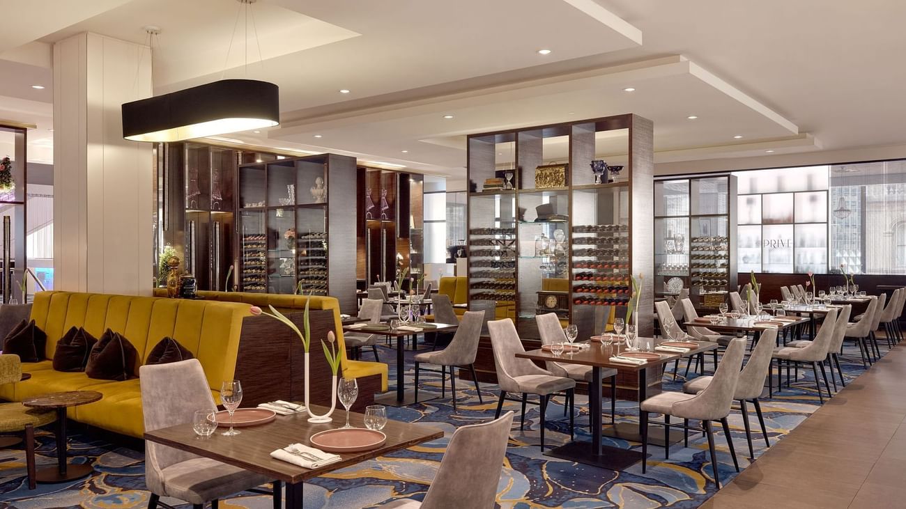 Modern interior with stylish chairs, tables set and decorative shelving in Suzette at Sofitel Brisbane Central