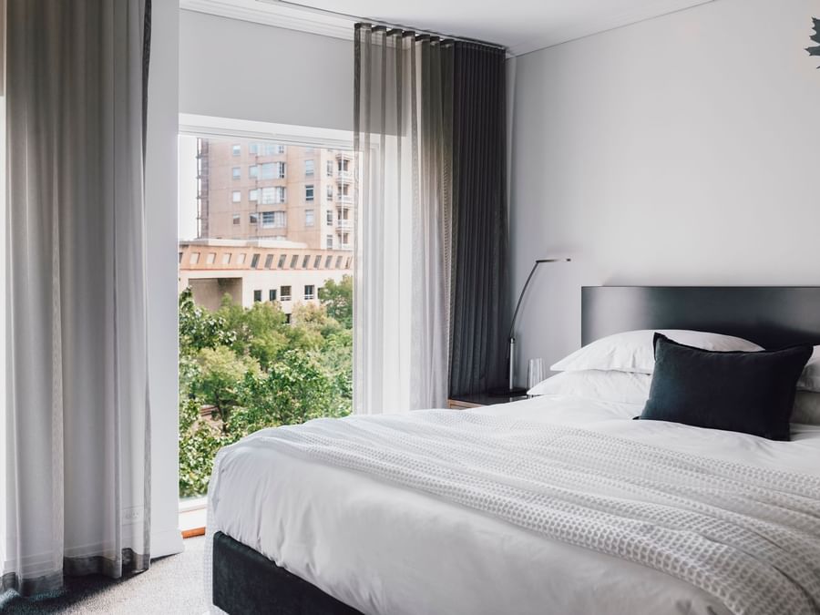 King bed by a window in Junior Suite at The Como Melbourne