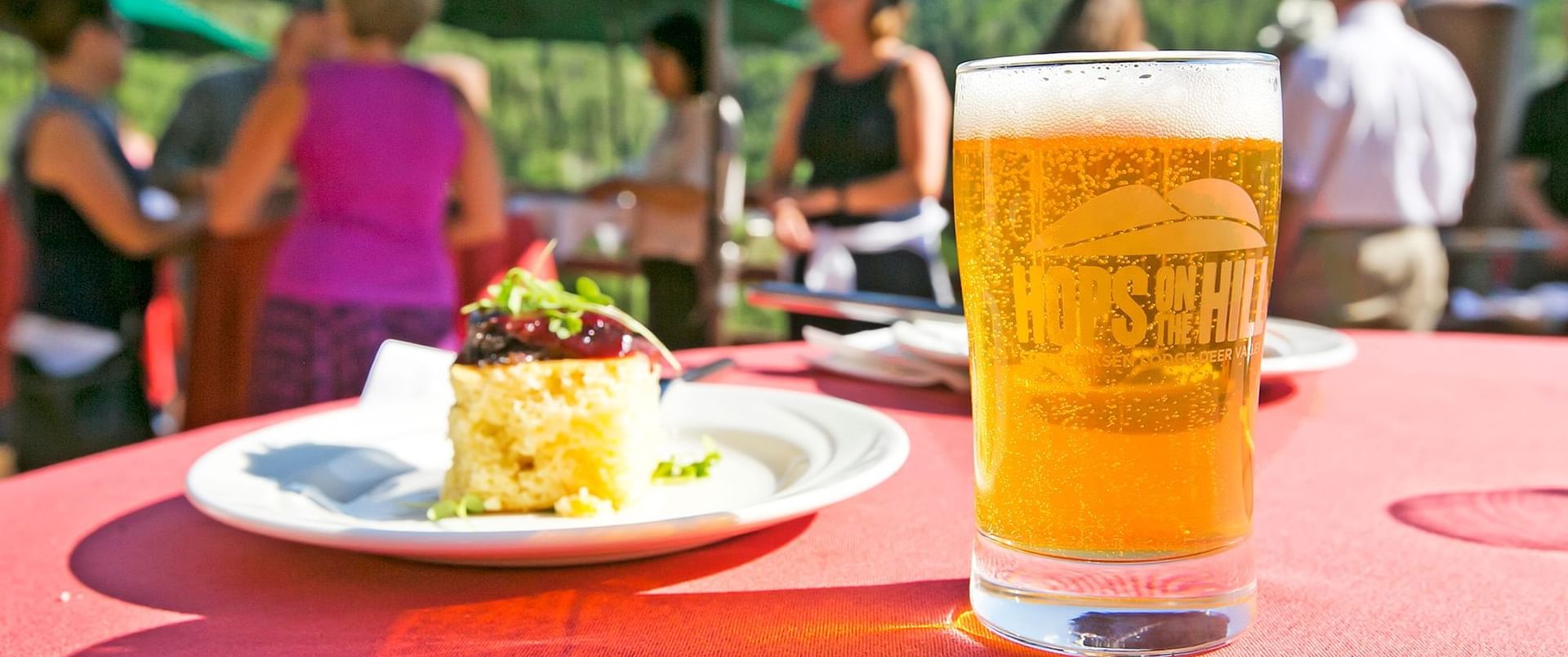 A plate of food and a beer is placed on a table near Stein Eriksen Residences