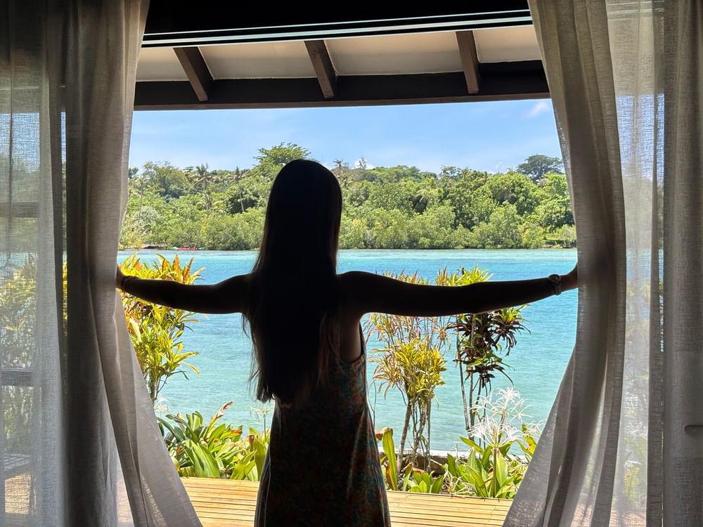 Woman enjoying a view from her Pacific Pool Villa at Warwick Le Lagon - Vanuatu in Efate.