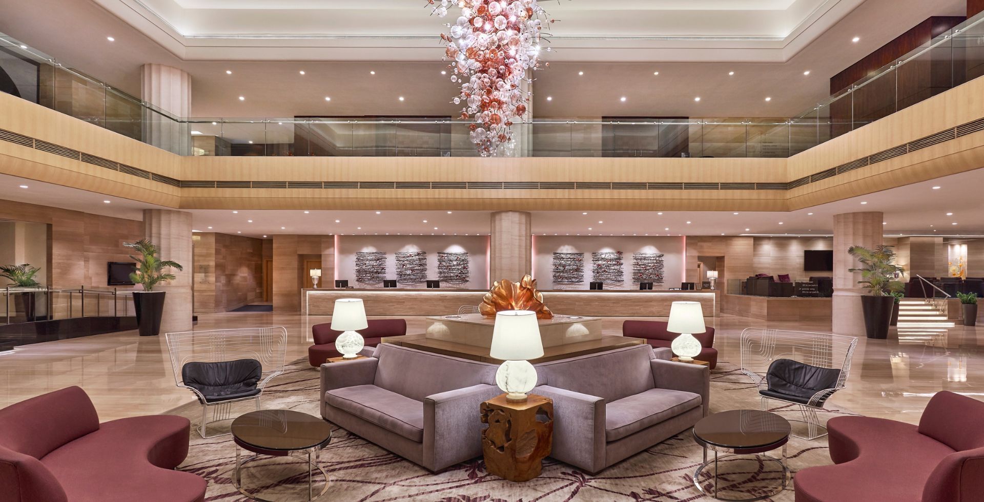 The spacious and elegant main lobby with a unique floral glass chandelier at Carlton Hotel Singapore reception area