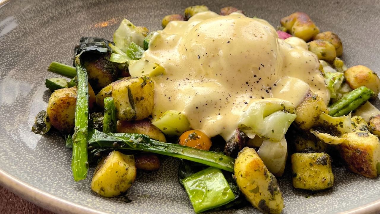 Assorted greens and vegetables covered in a hollandaise sauce