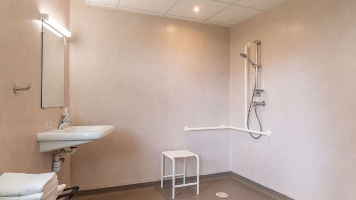 Bathroom shower & vanity area in a room at ara hotel