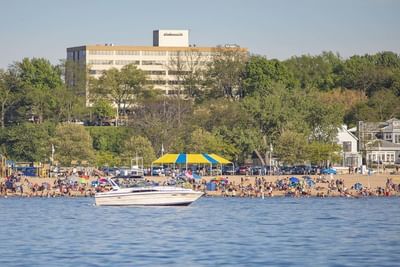 Scenic beach view with a boat on the water and people relaxing on the sand near The Boulevard Inn & Bistro