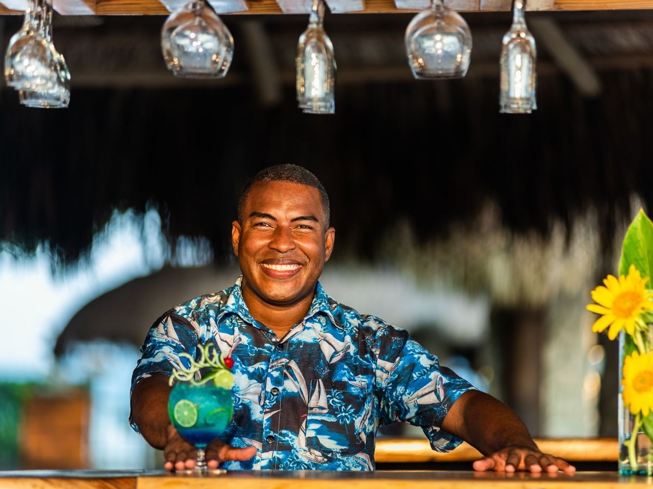 A man holding a Fish Bowl Drink while smiling at Hotel Isla Del Encanto