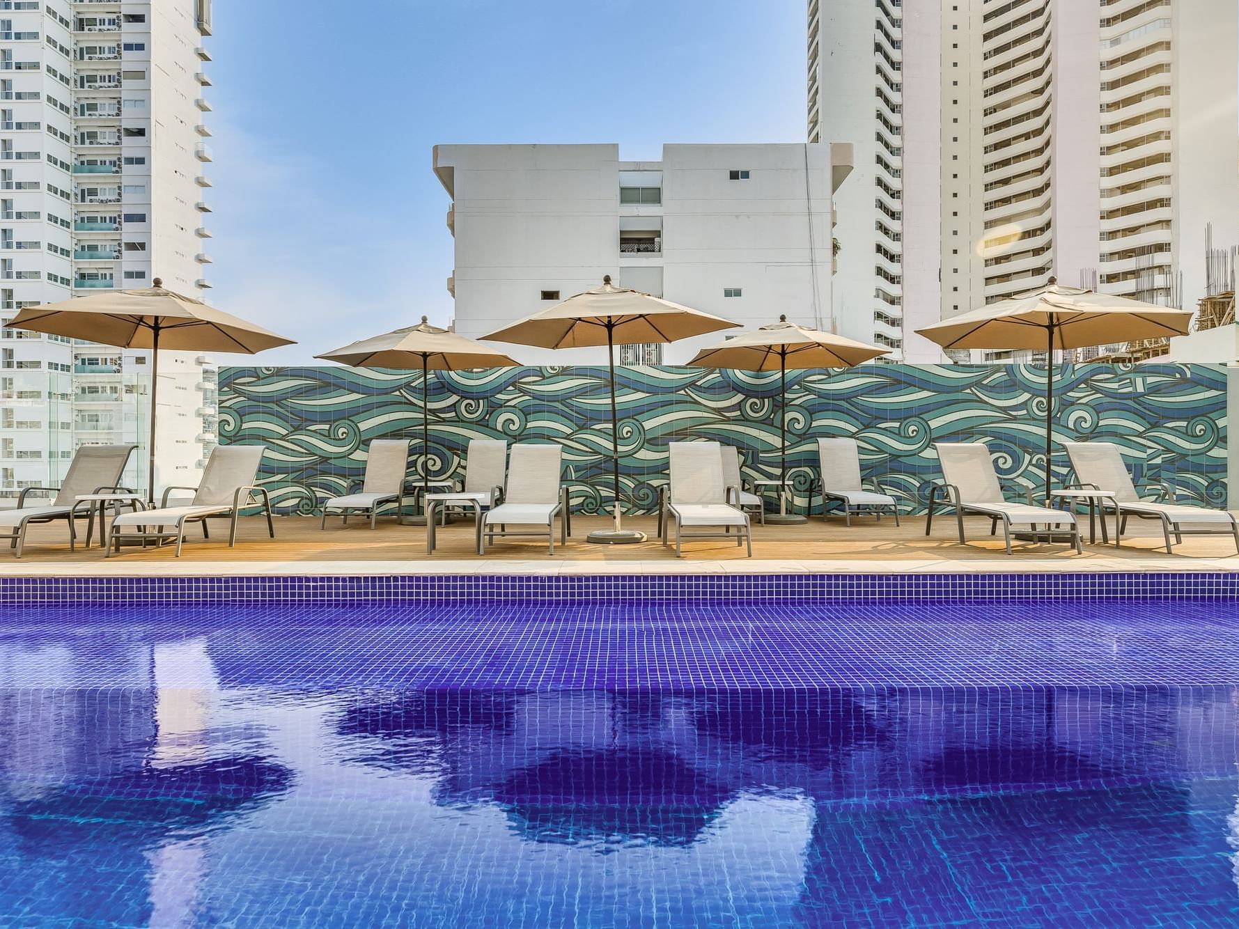 Outdoor swimming pool with sunbeds at One Hotels