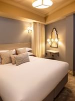 Bed under wall lamp with vanity table in Hyde Park Suite at The Capital Hotel, Apartments and Townhouse