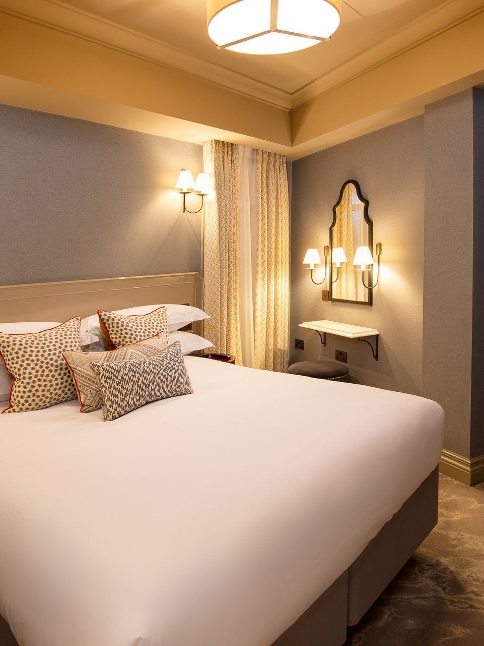 Bed under wall lamp with vanity table in Hyde Park Suite at The Capital Hotel, Apartments and Townhouse