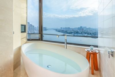A Bathtub with a city view in deluxe room at White Swan Hotel