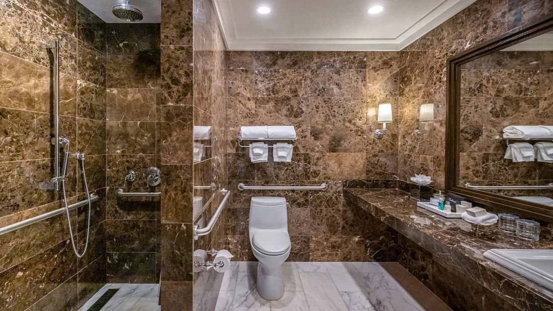 Deluxe Queen Queen with cozy beds, blue headboards, and plush seating at El Prado Hotel