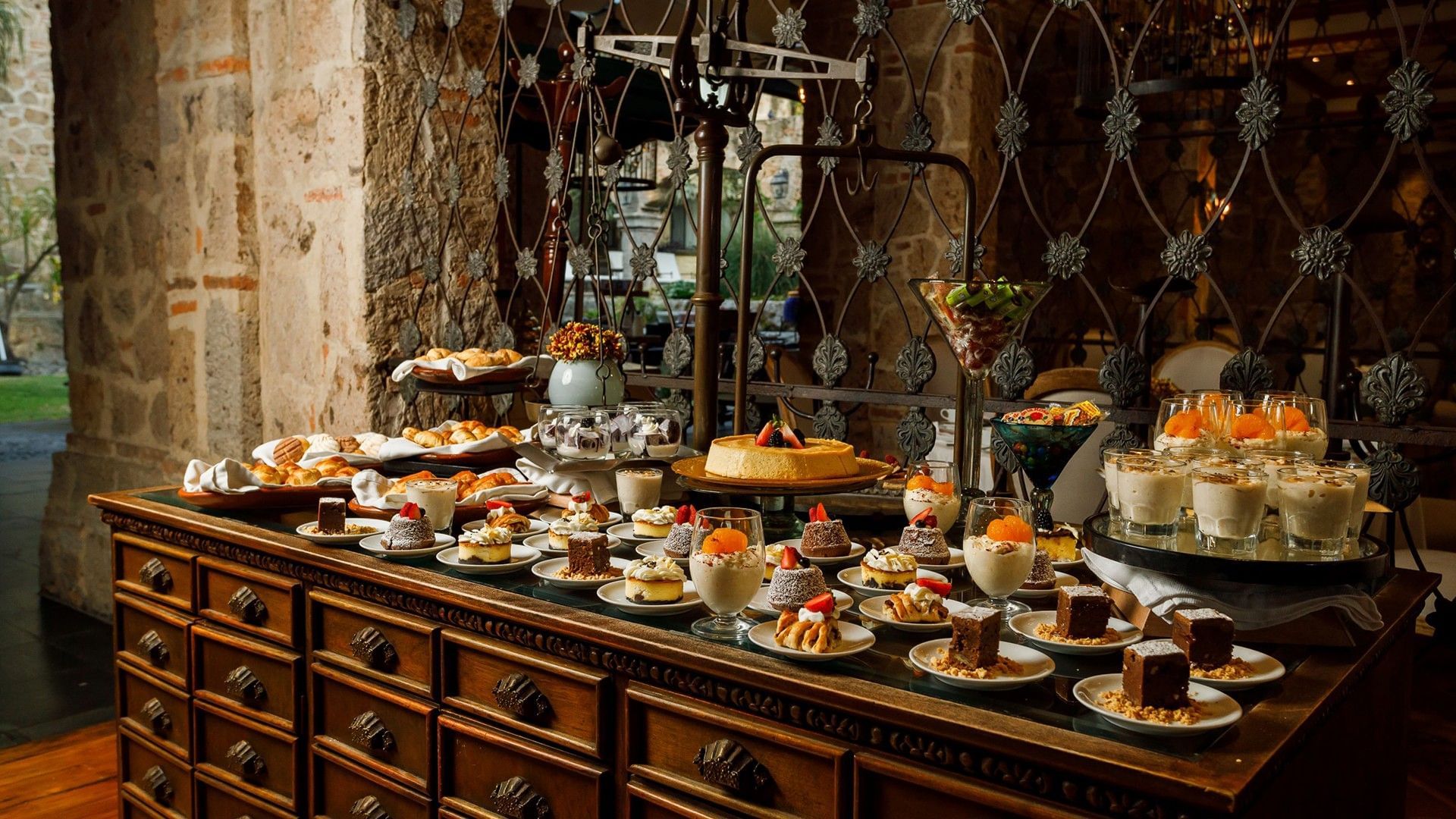 Tierra Mia restaurant dessert spread with cakes and puddings on a vintage wooden buffet at Quinta Real Guadalajara