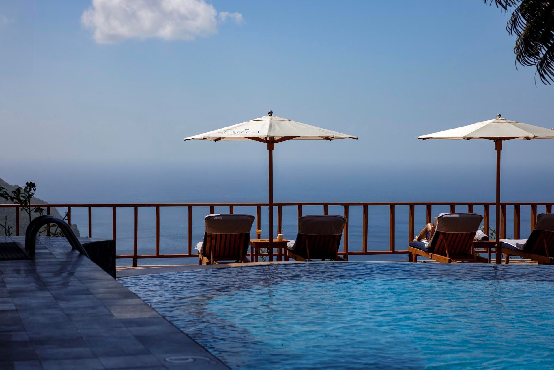 Sun loungers arranged by an outdoor pool at Pitons St Lucia Resort