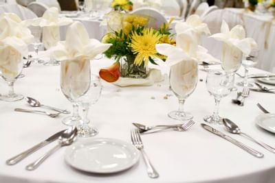 Close-up on glassware and floral decor on a banquet table at Acclaim Hotel Calgary